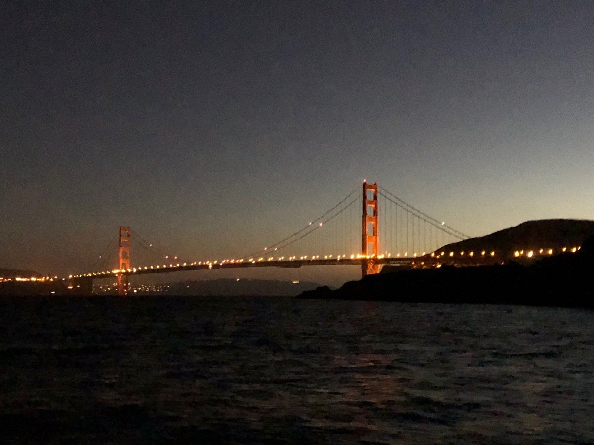 The Golden Gate Bridge lit up at night.
