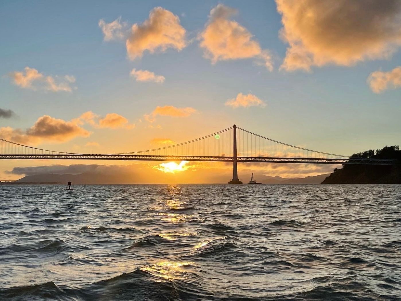 A golden sun set behind the Golden Gate Bridge.