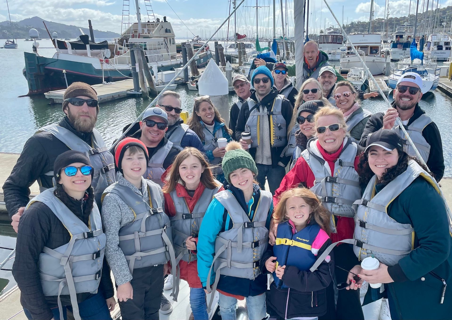 A large group posing on the bow of Bay Wolf before setting sail.