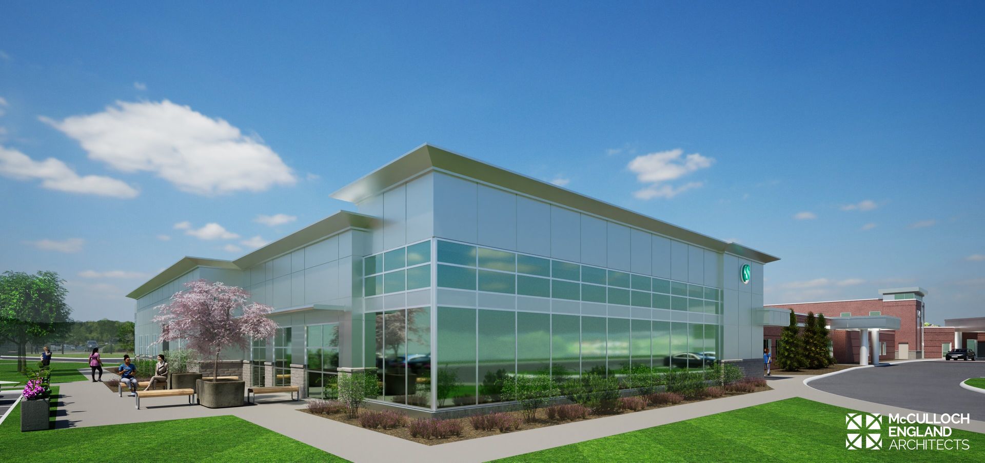 Modern building with glass walls, outdoor seating, and a green lawn under a bright blue sky.
