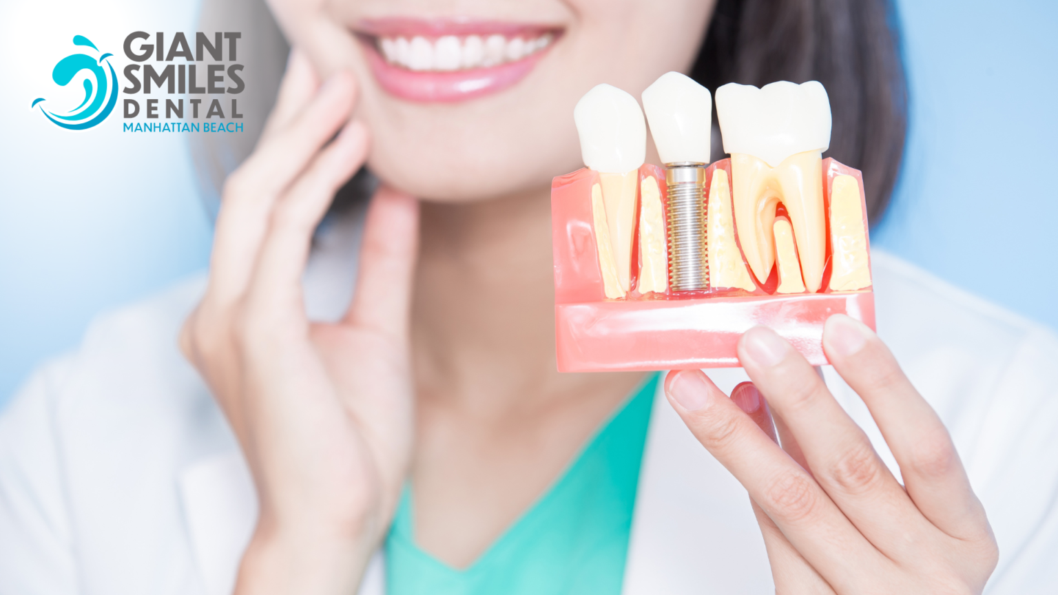 A woman is smiling while holding a model of her teeth.