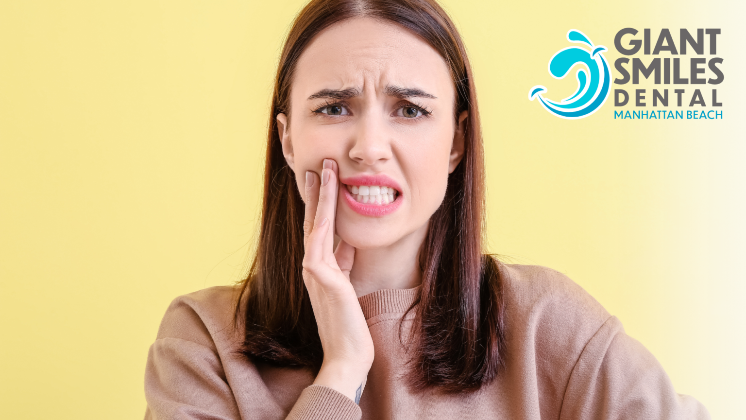 A woman is holding her mouth in pain because of a toothache.