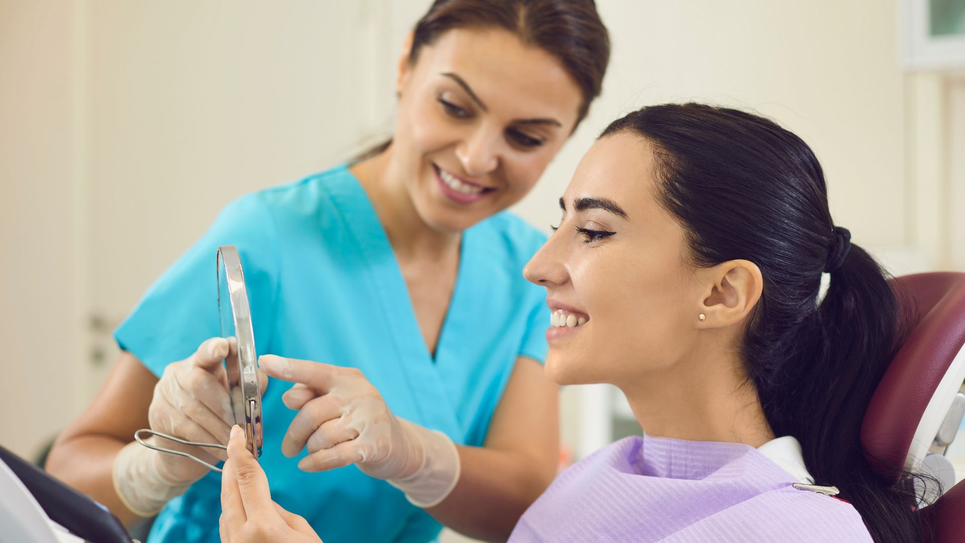 Dentist examining patient's teeth in a dental chair; medical tools visible.