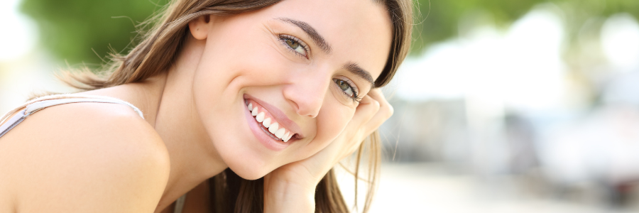A dentist is holding a model of a person 's teeth with tweezers.
