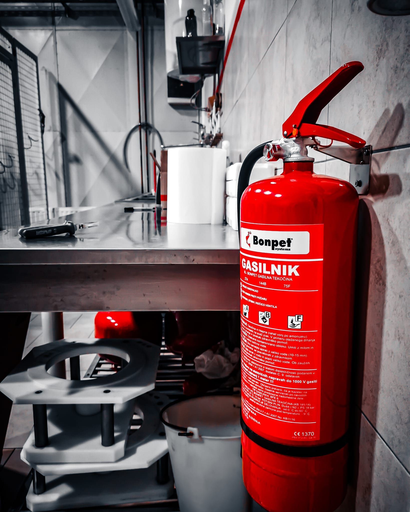 Een rode brandblusser, gemonteerd aan de muur in een keuken.