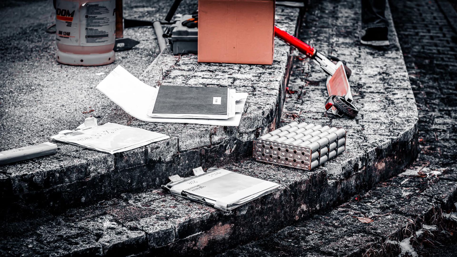 Diverse gereedschappen en materialen op verweerde bakstenen trappen.