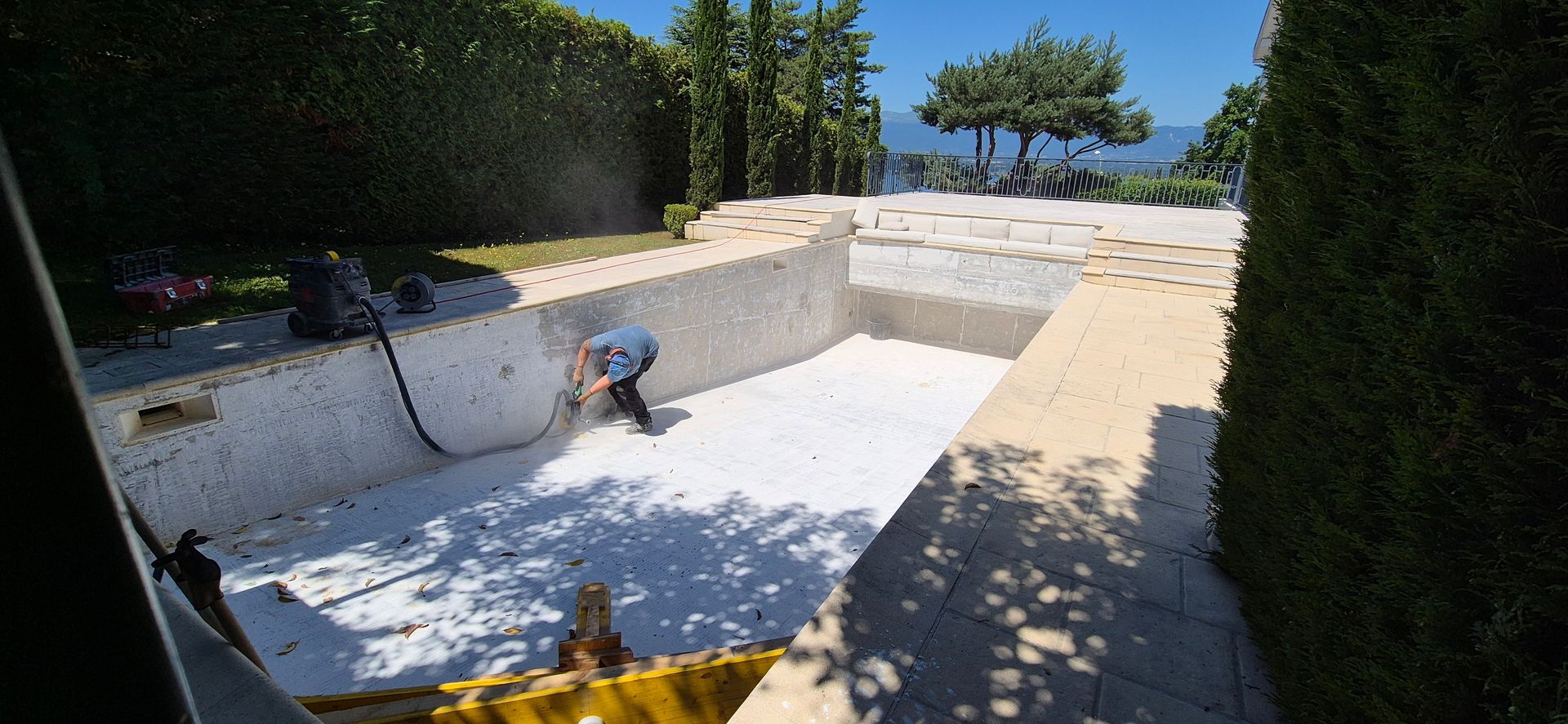 Un homme travaille au bord d'une piscine.