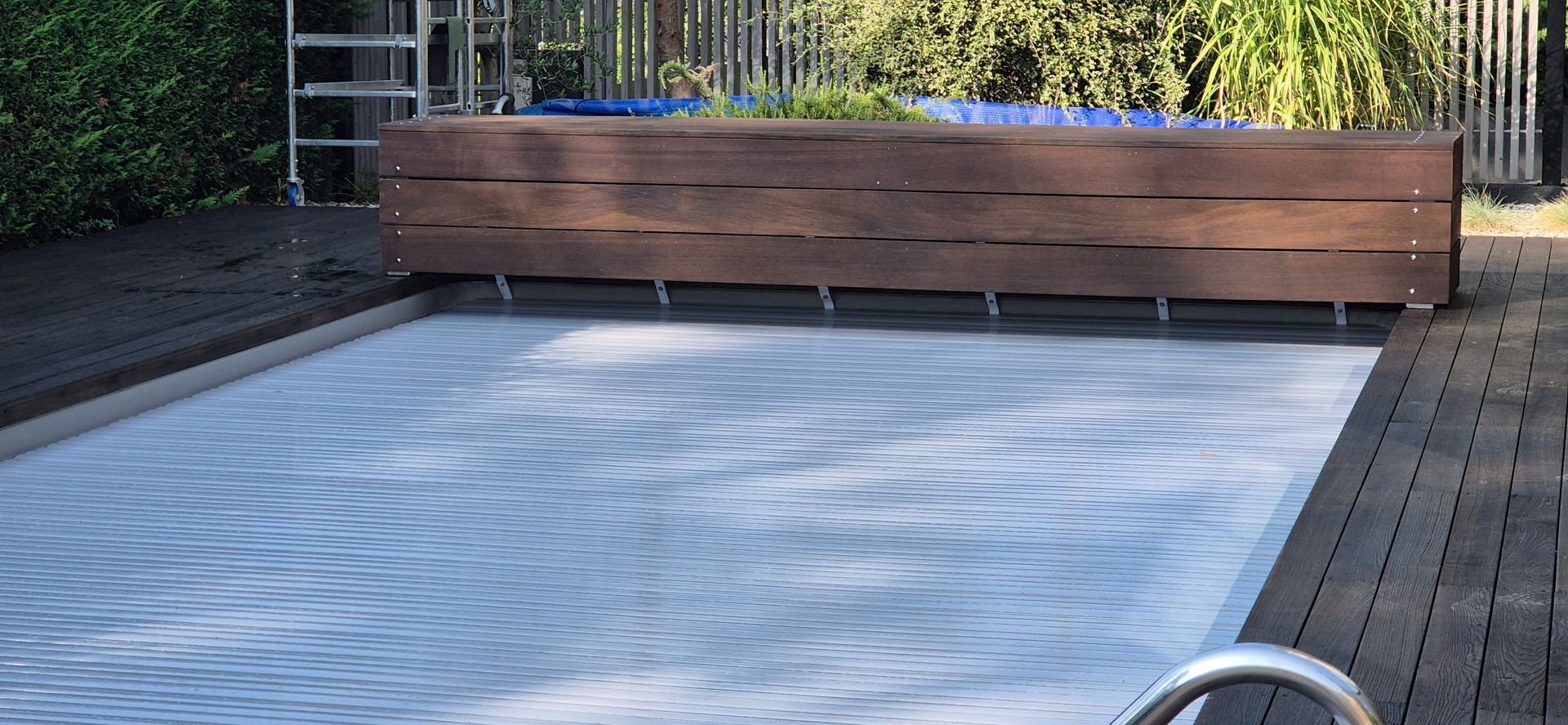 Une piscine entourée d'une clôture en bois.