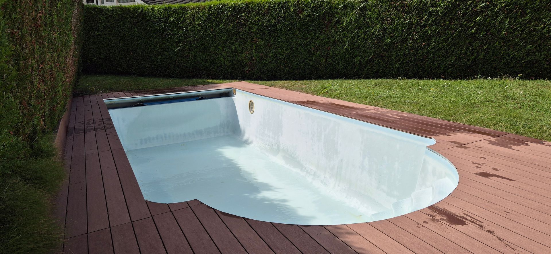 Une piscine est installée sur une terrasse en bois dans une cour arrière.