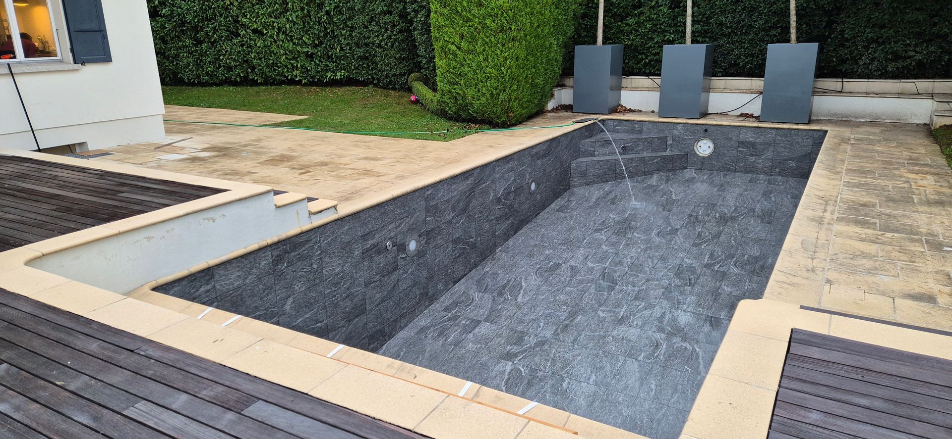 Une grande piscine se trouve dans l'arrière-cour d'une maison.