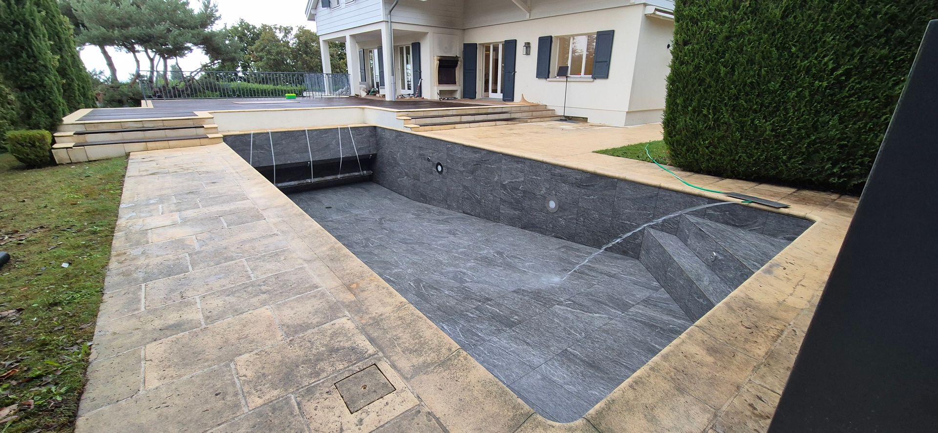 Une piscine vide devant une maison