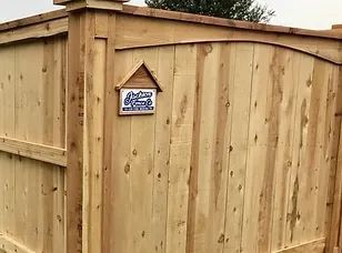 Wooden fence with a small decorative sign near the top.