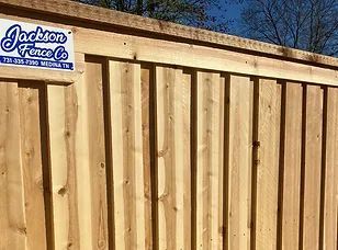 Wooden privacy fence with a Jackson Fence Co. sign in the upper left corner