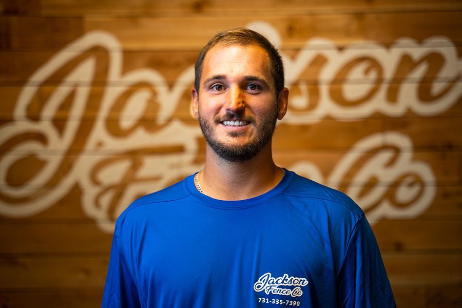 Man in blue shirt smiling in front of a wood wall with the Johnson Family logo
