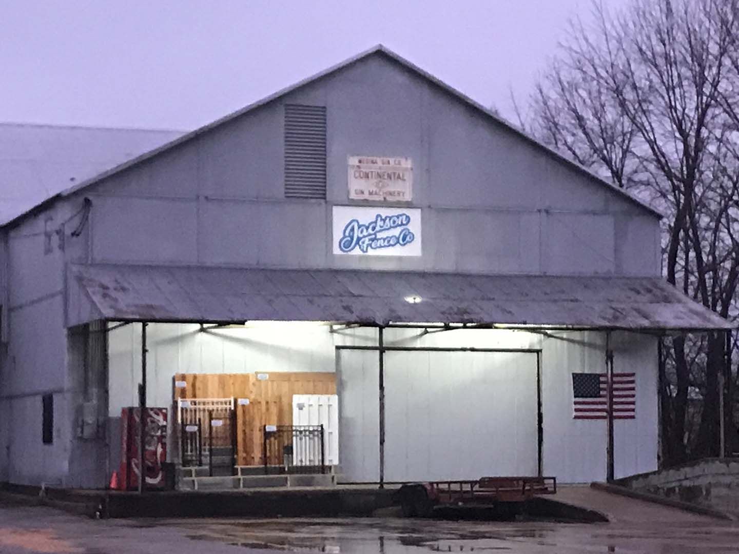 Snowy storefront with an open loading bay, lit interior, and an American flag on the wall
