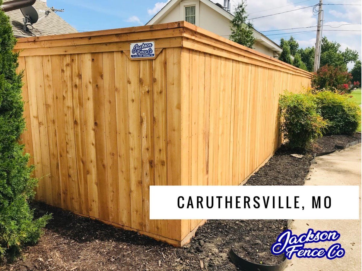 Wooden privacy fence with gate in a suburban yard, labeled Caruthersville, MO.
