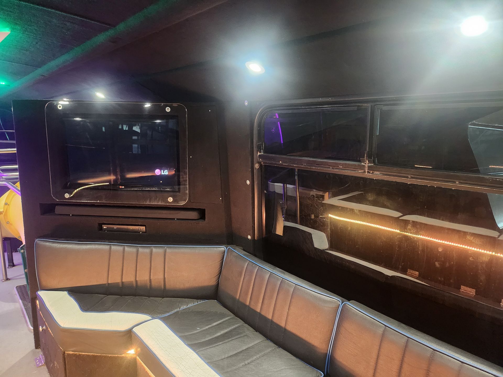 There is a couch and a television in the back of the bus.