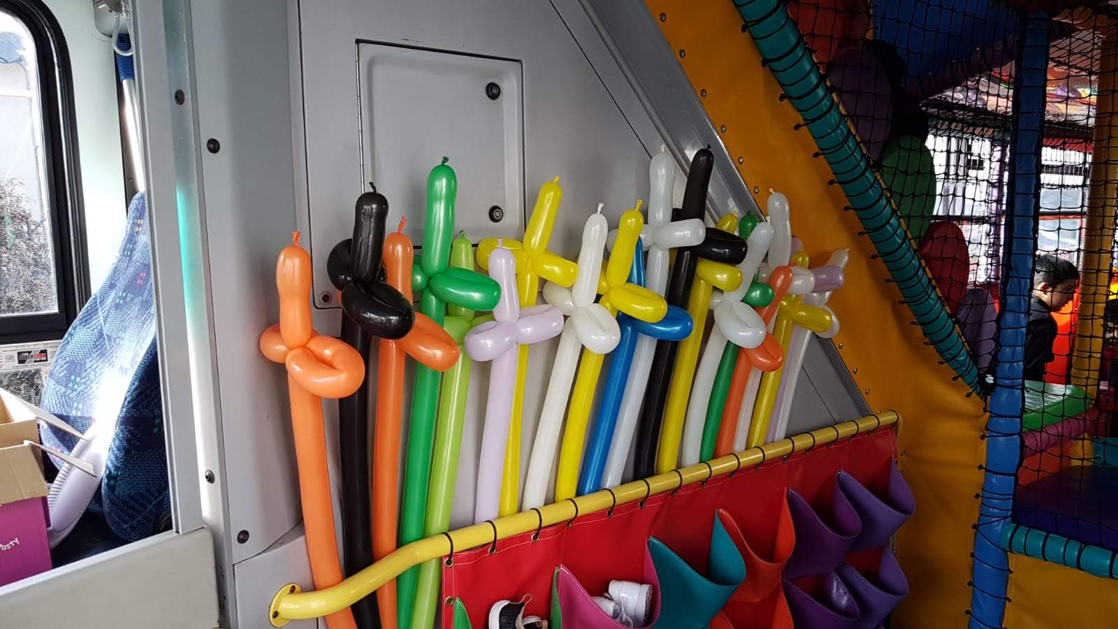 A bunch of colorful balloons are hanging on a wall.