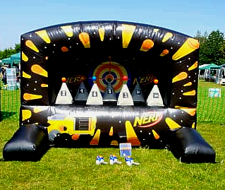 A large inflatable nerf target is sitting on top of a lush green field.