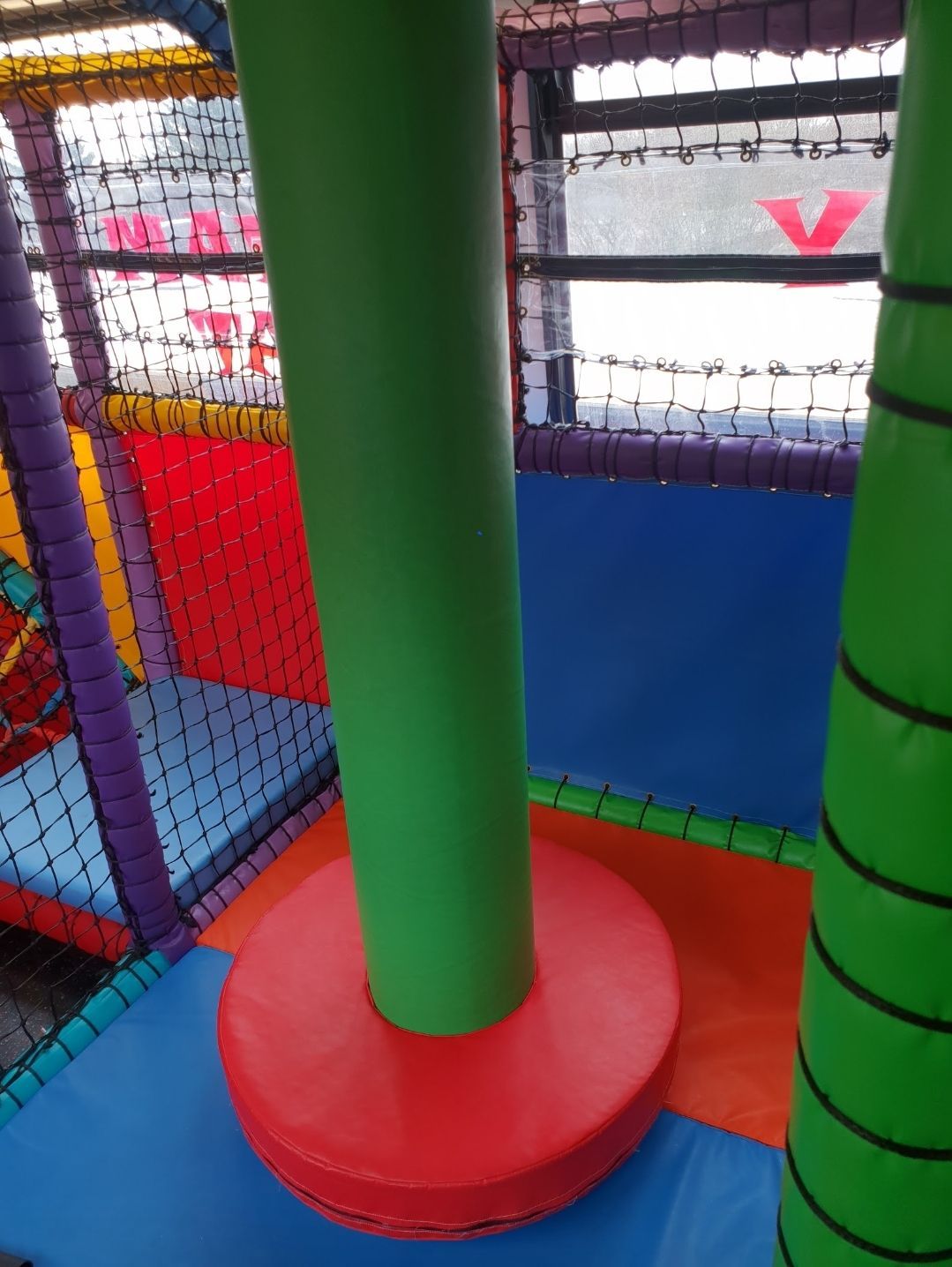 A colorful playground with a green pole in the middle