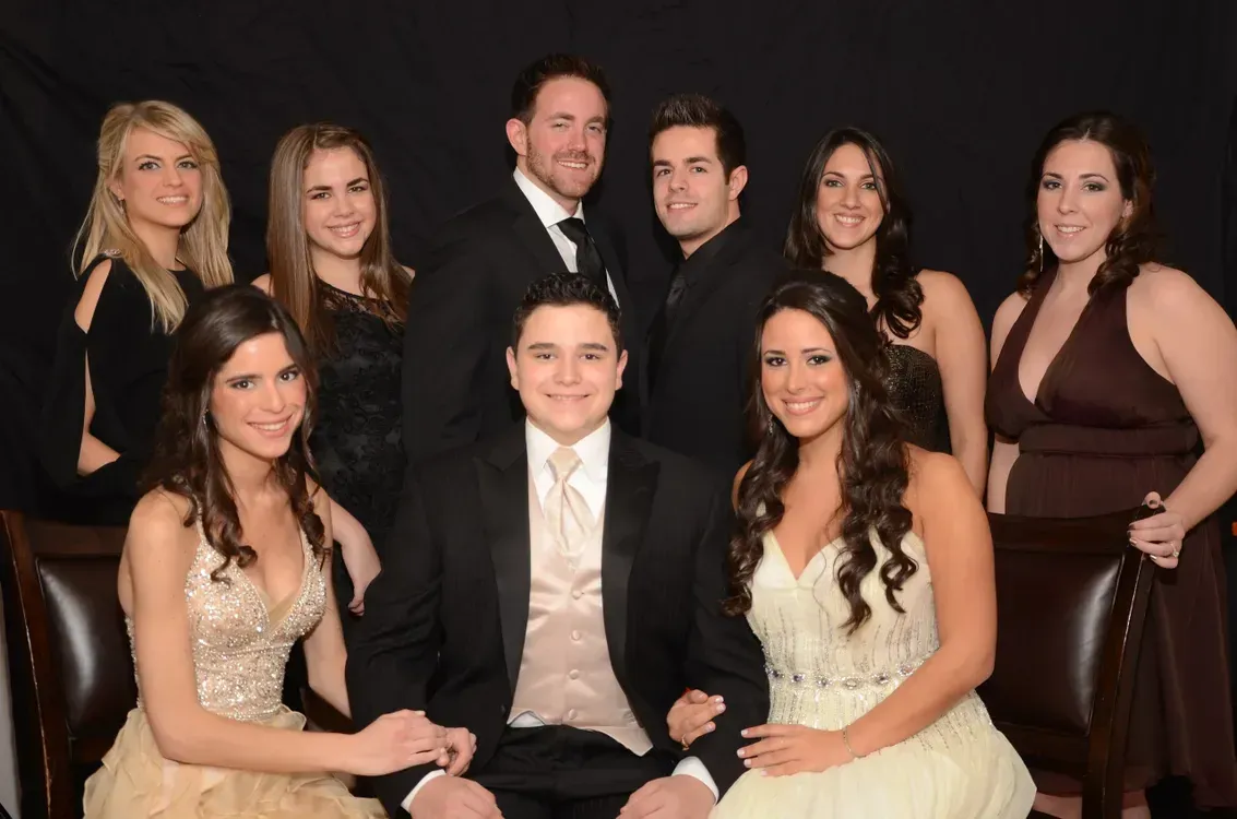 A group of people posing for a picture in front of a black background
