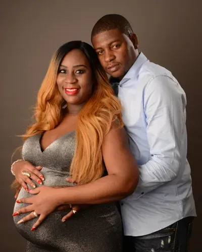 A man and a pregnant woman are posing for a picture.