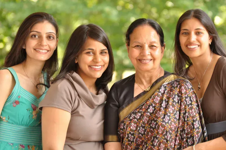Four women are posing for a picture and smiling for the camera