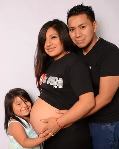 A pregnant woman wearing a black shirt that says mama