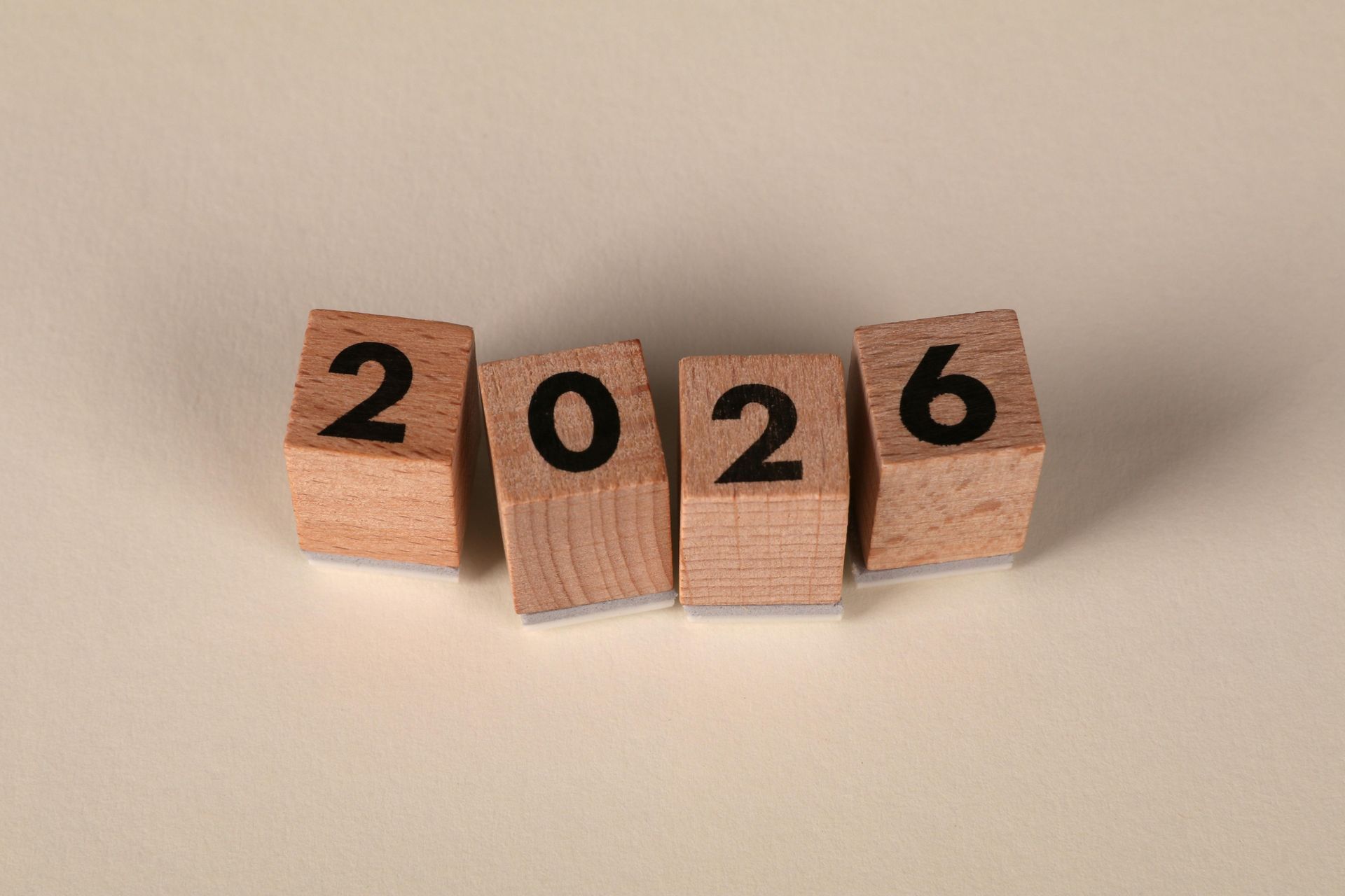 2026 in gold on black cubes, with fireworks and gold star-like shapes in background.