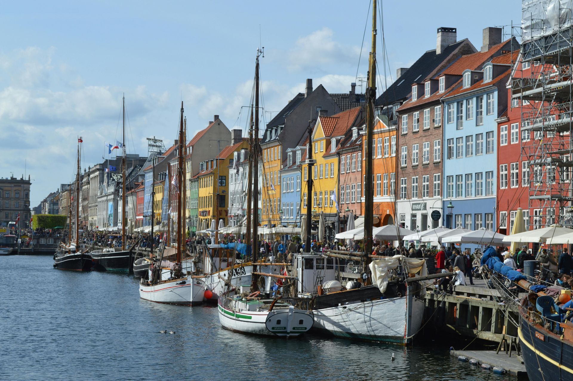 Boats docked along colorful buildings in Copenhagen, Denmark.