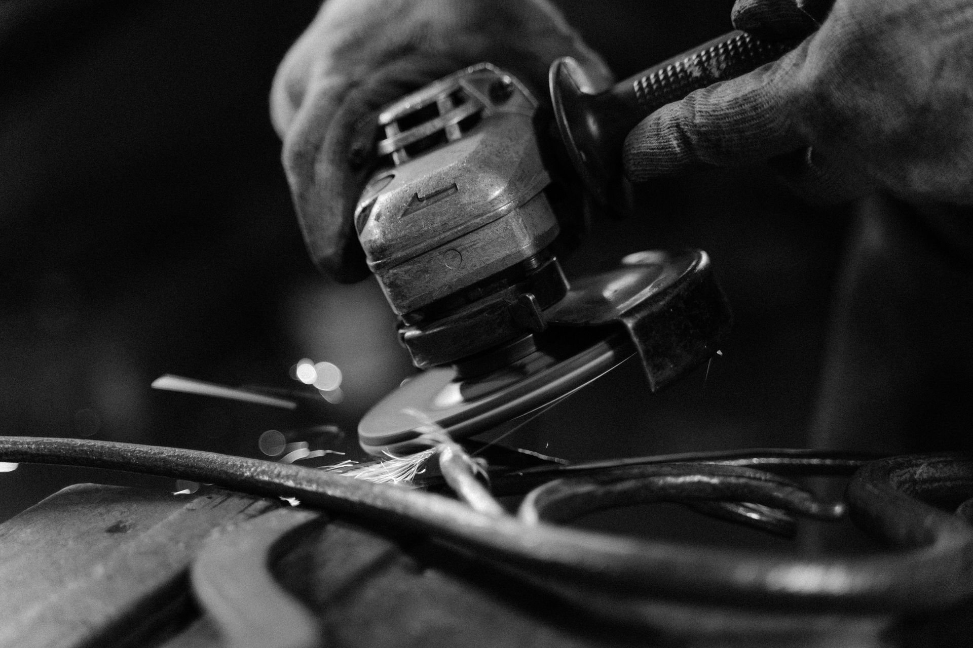 A person is grinding a piece of metal with a grinder.