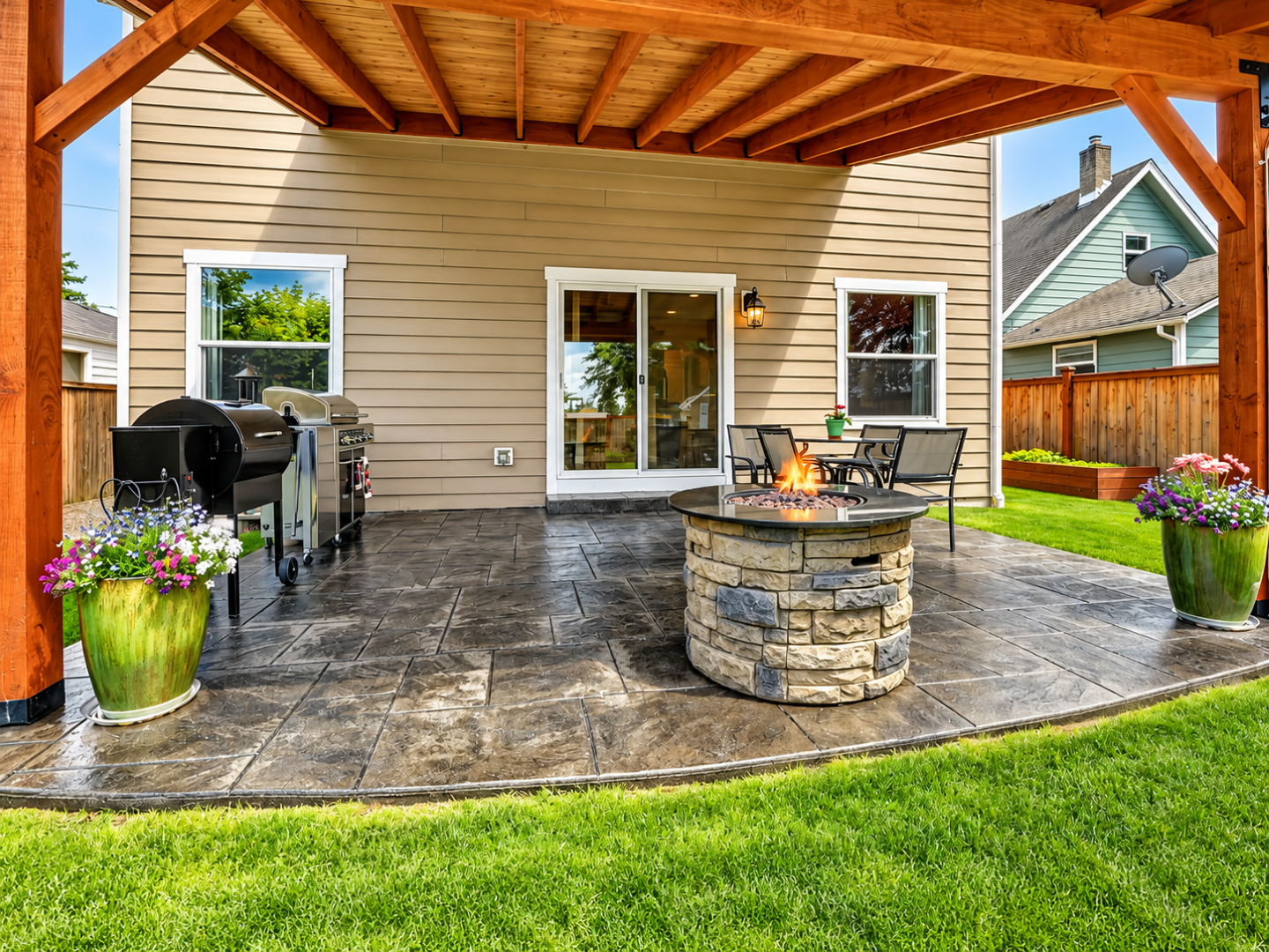 Covered concrete patio with outdoor kitchen and seats after Concrete Services in Minnetonka, MN for backyard gatherings.