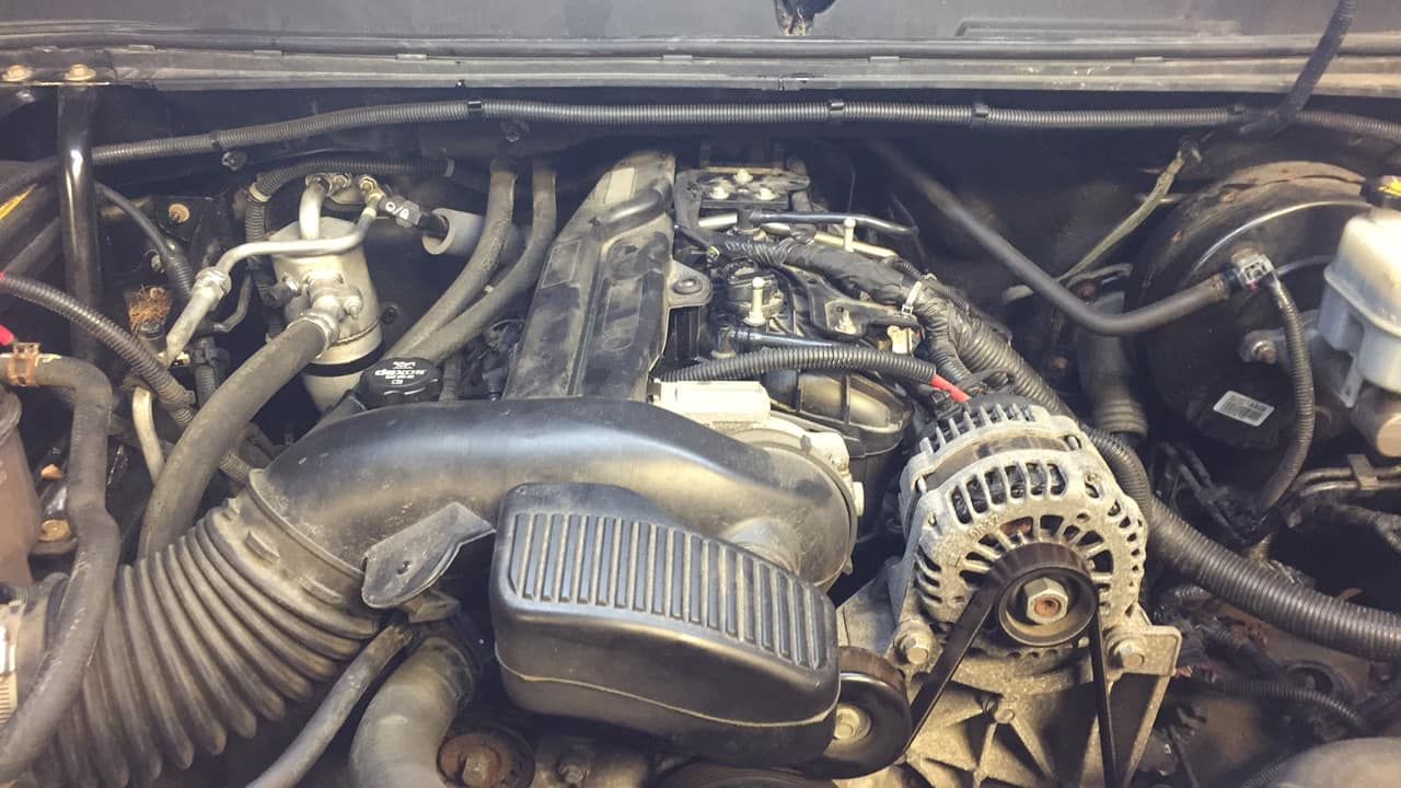 A close up of a car engine with a alternator.