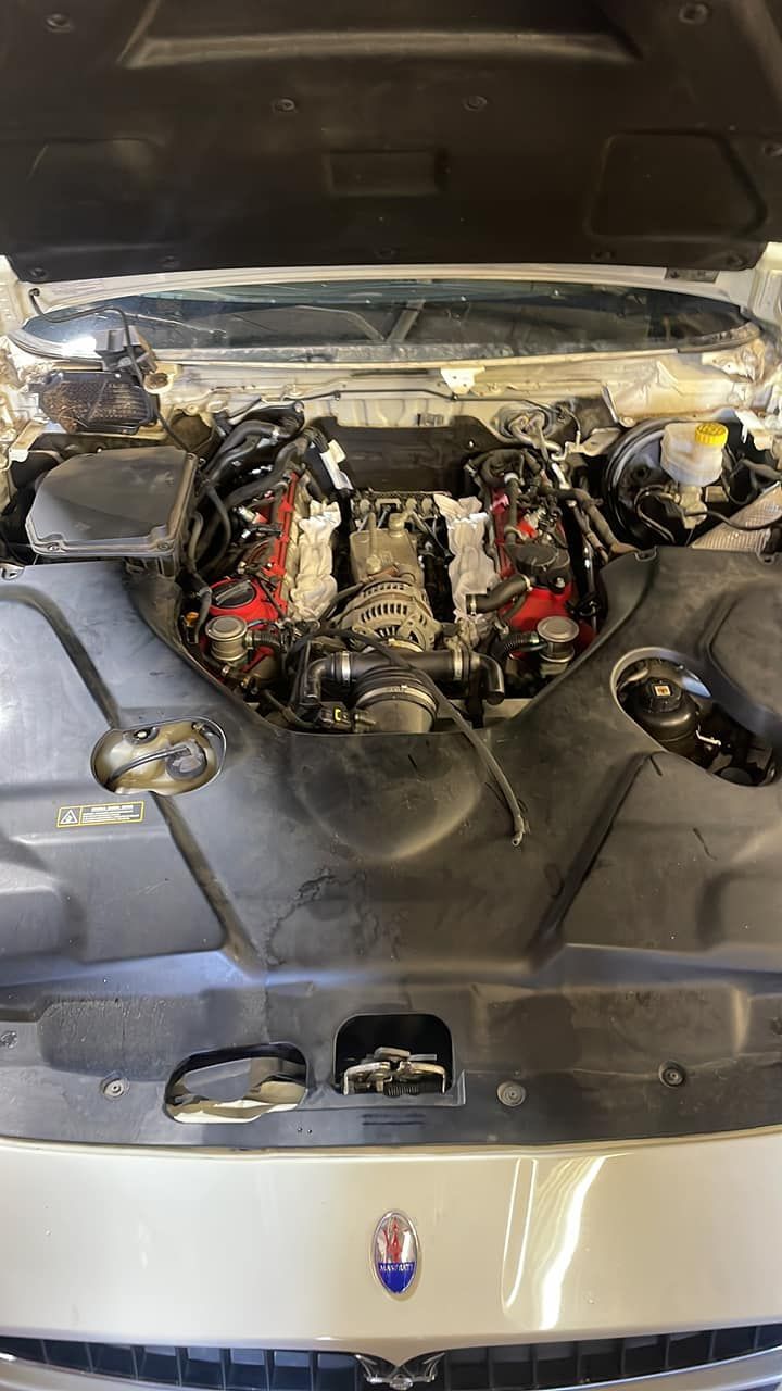 A close up of a car engine with the hood open.