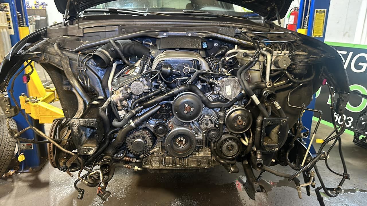 A car engine is being dismantled in a garage.