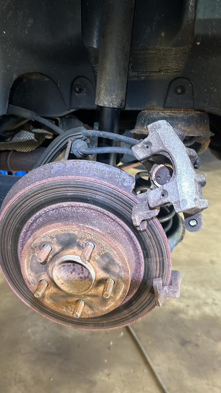 A close up of a rusty brake disc on a car.