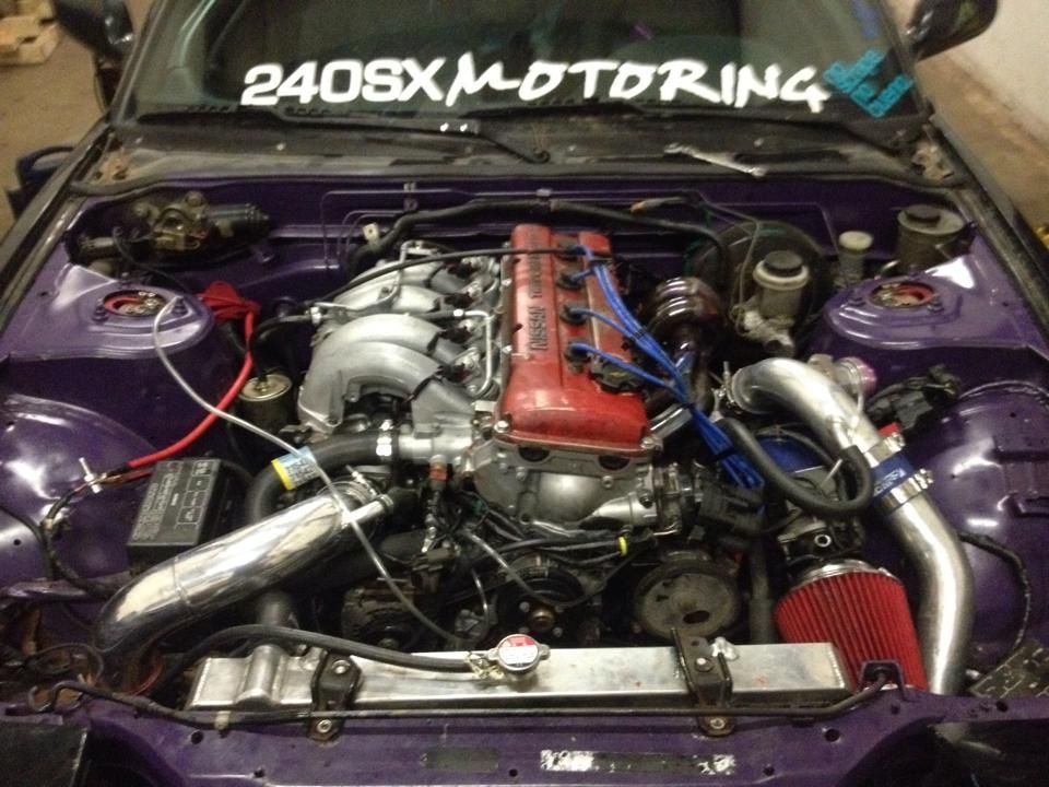 A purple car with a sticker on the windshield that says 240sx motoring