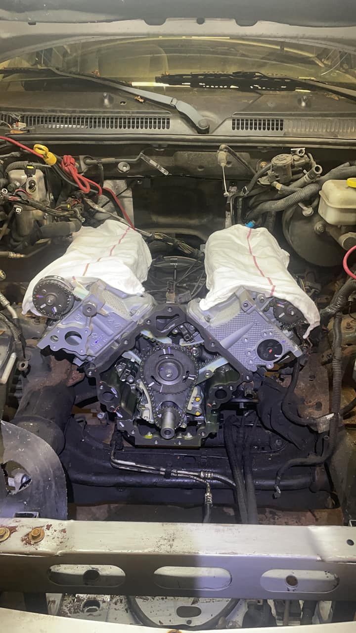 A close up of a car engine with a towel wrapped around it.