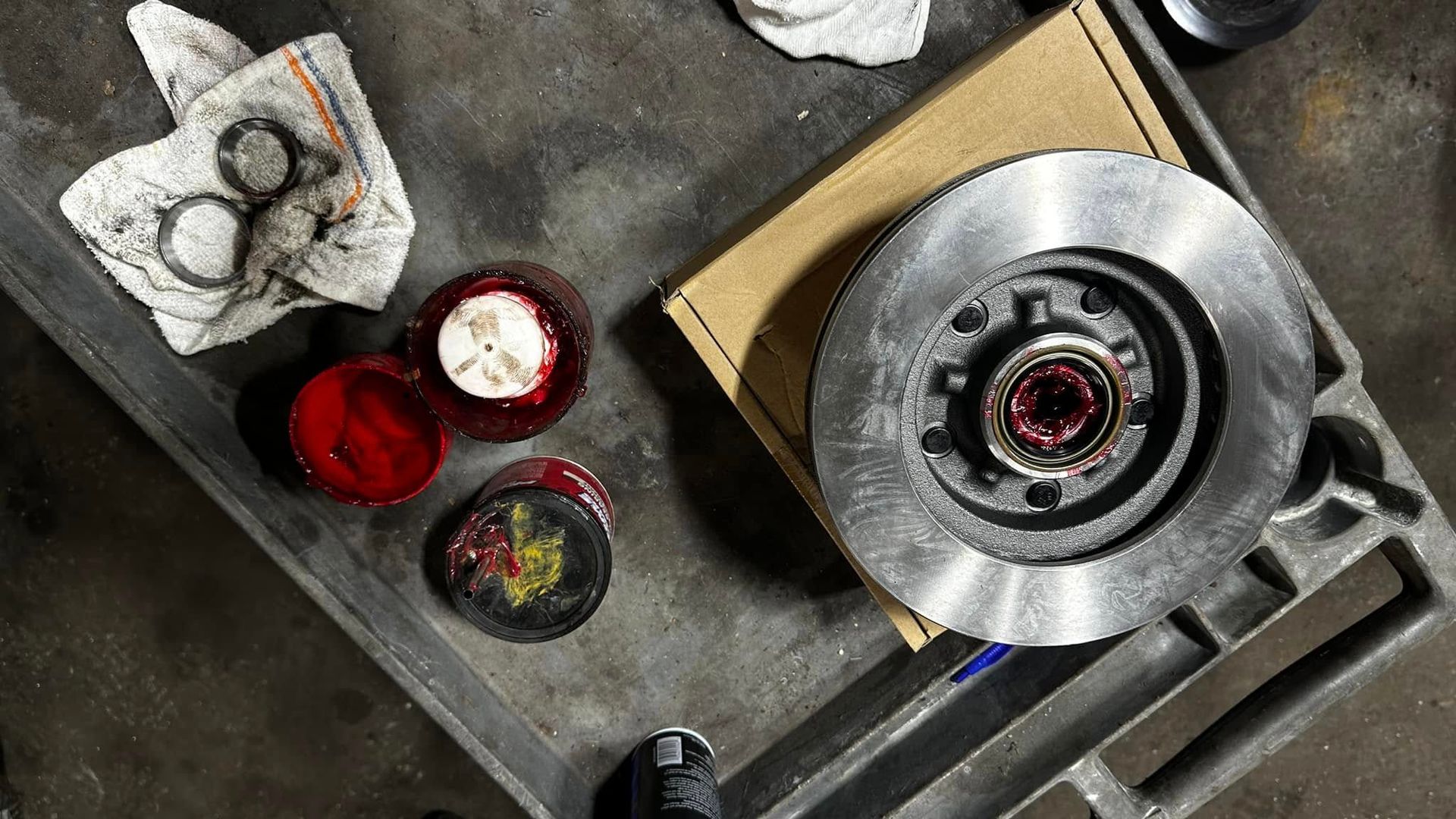 A brake disc is sitting on top of a metal tray.