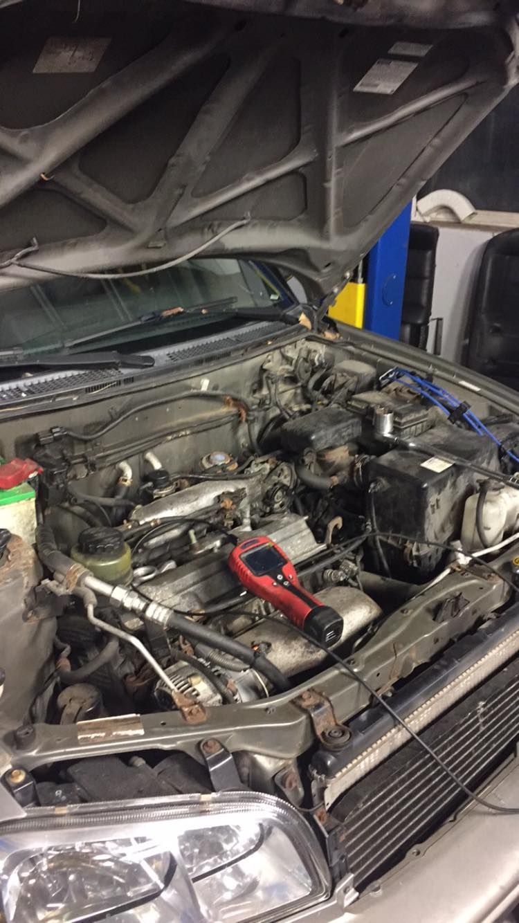 The engine of a car is being worked on with the hood open.