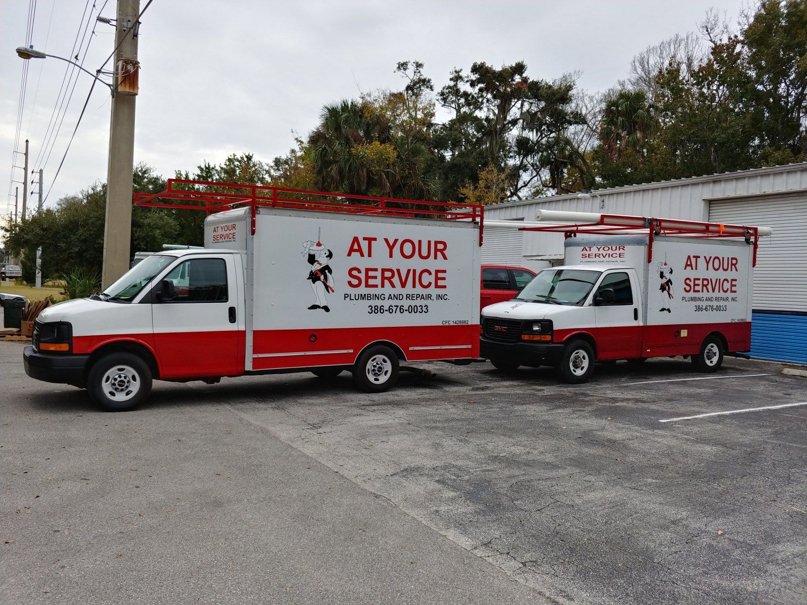 Two red and white service trucks with
