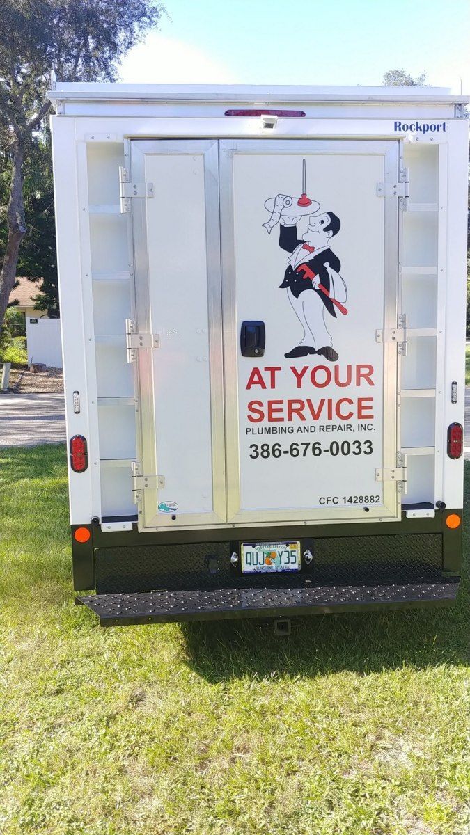 White service truck with door graphic of a cartoon chef; text reads