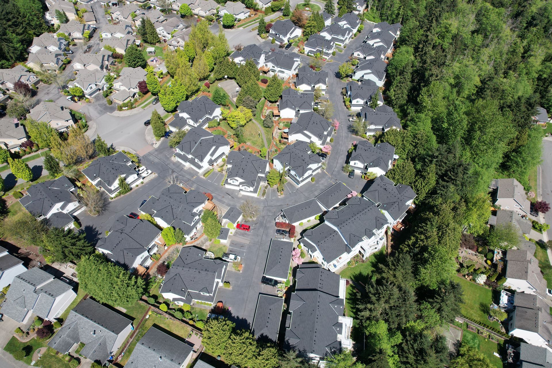 An aerial view of a residential area with lots of houses and trees taken by Riverside Roofing