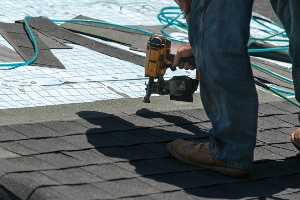 man nailing in roof shingles on a home in Marysville WA from Riverside Roofing