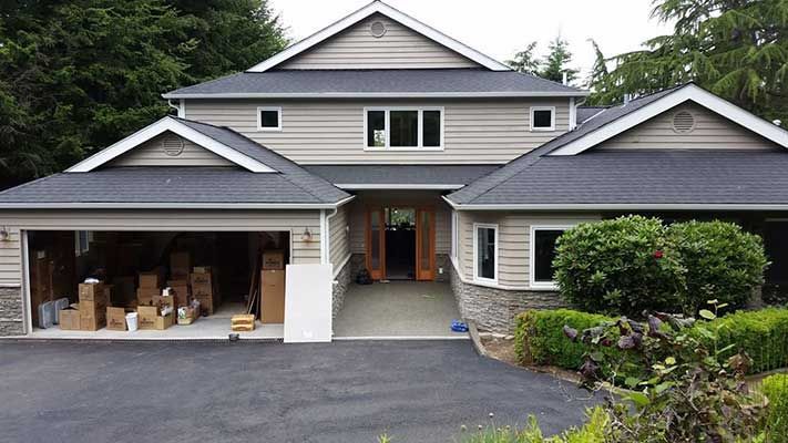 A large house with a lot of boxes in the garage taken by Riverside Roofing
