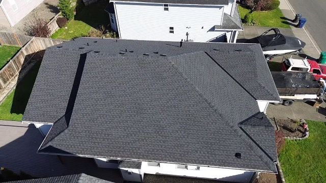 An aerial view of a house with a new roof taken by Riverside Roofing