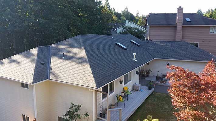 An aerial view of a house with a black roof taken by Riverside Roofing