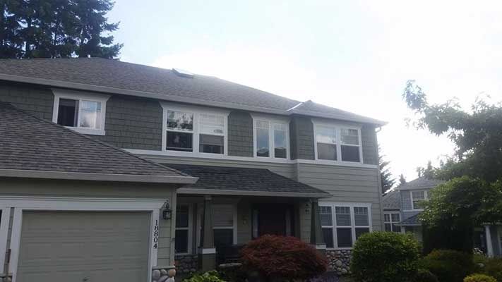 A large house with a garage and a lot of windows taken by Riverside Roofing