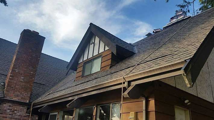A house with a roof that has a chimney on it taken by Riverside Roofing