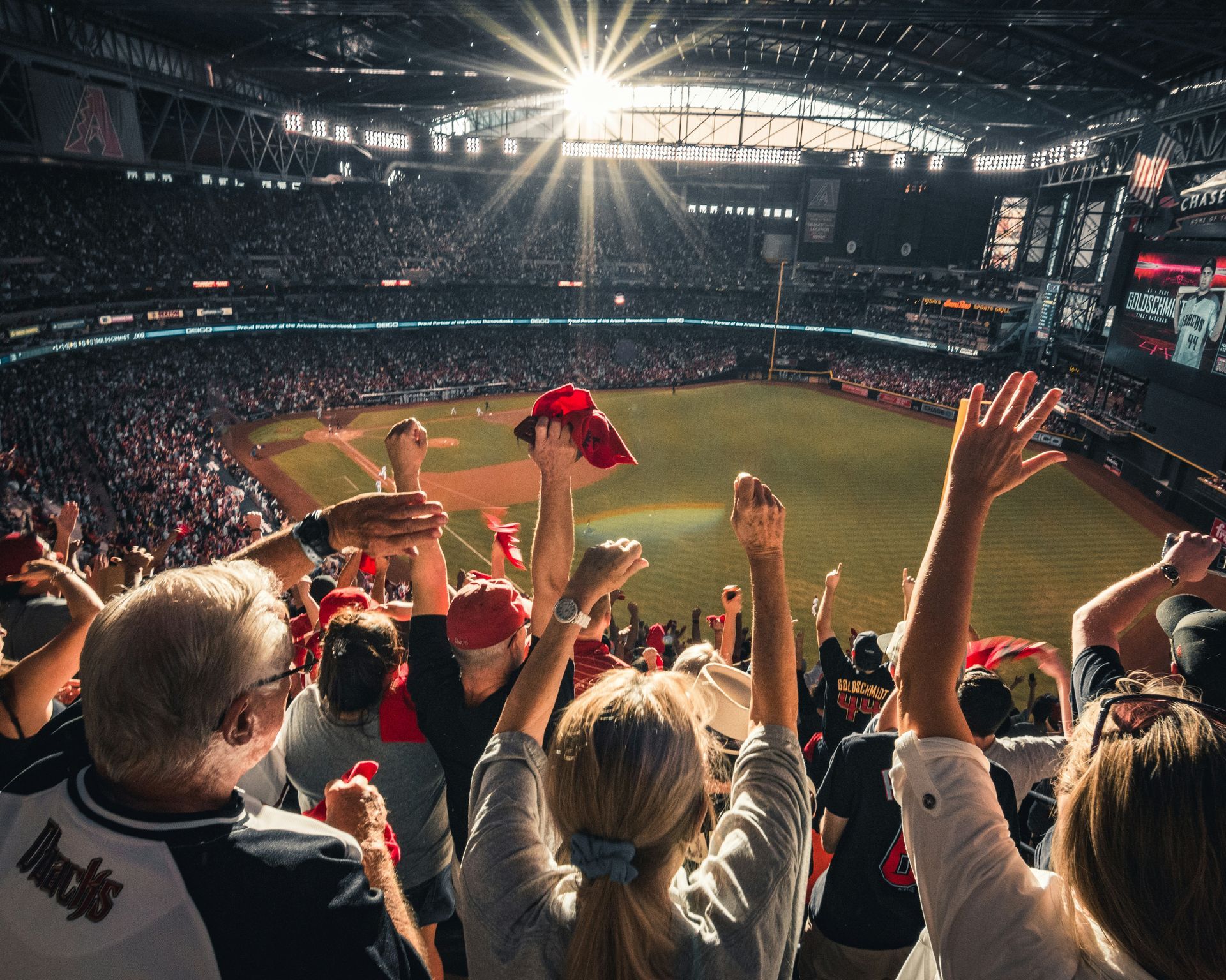 a crowd of people are watching a baseball game in a stadium .